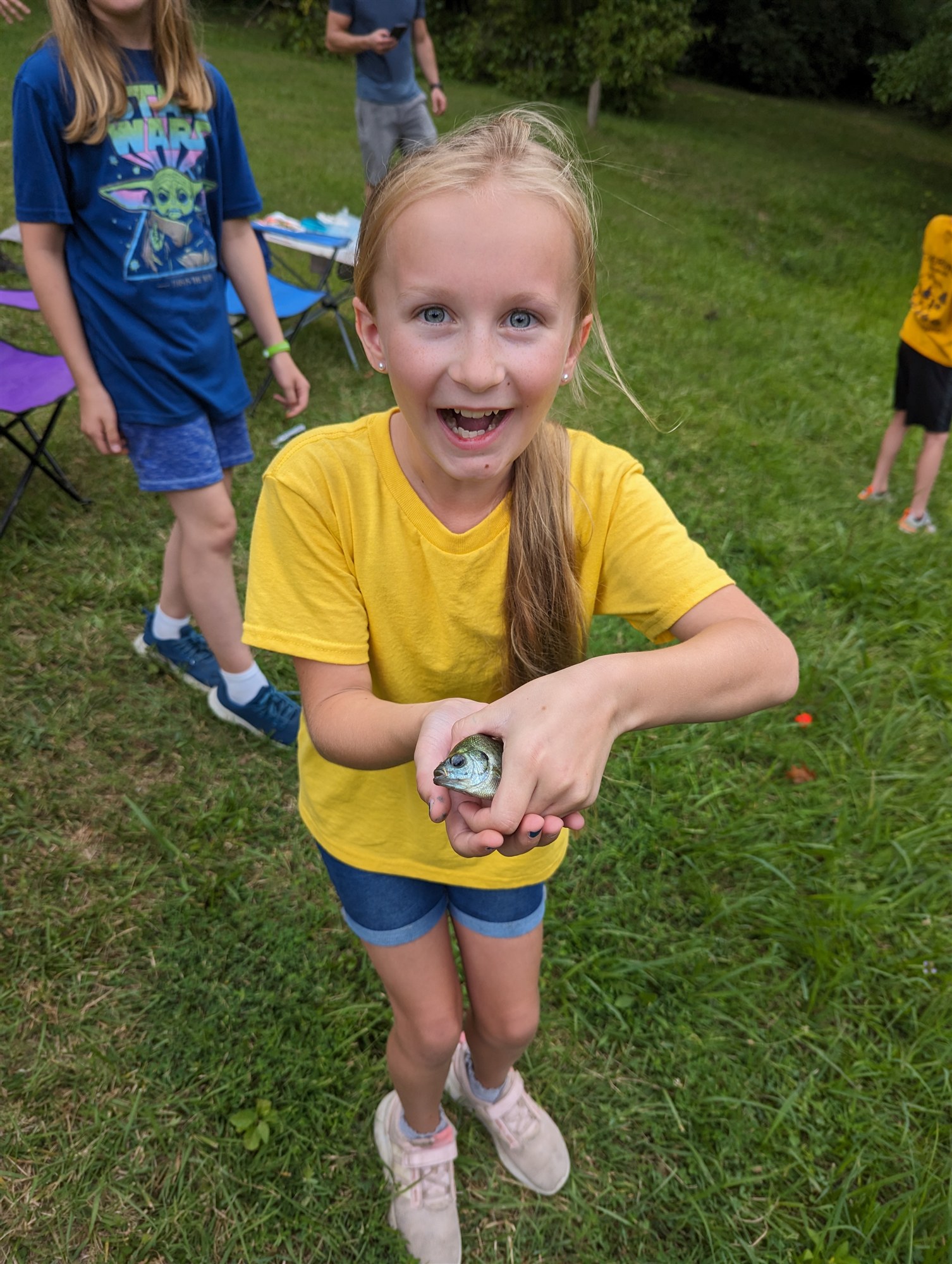 A young Lucy proudly holding her first fish