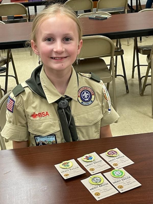 Lucy in uniform proudly displaying her first merit badges