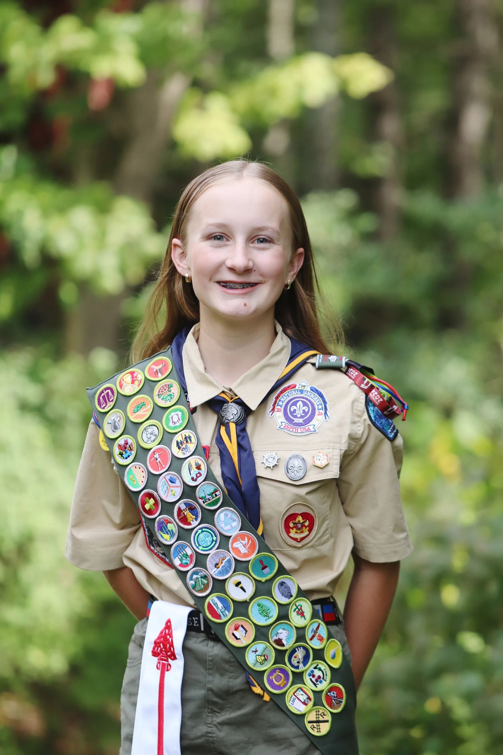 Lucy in uniform wearing her merit badge sash