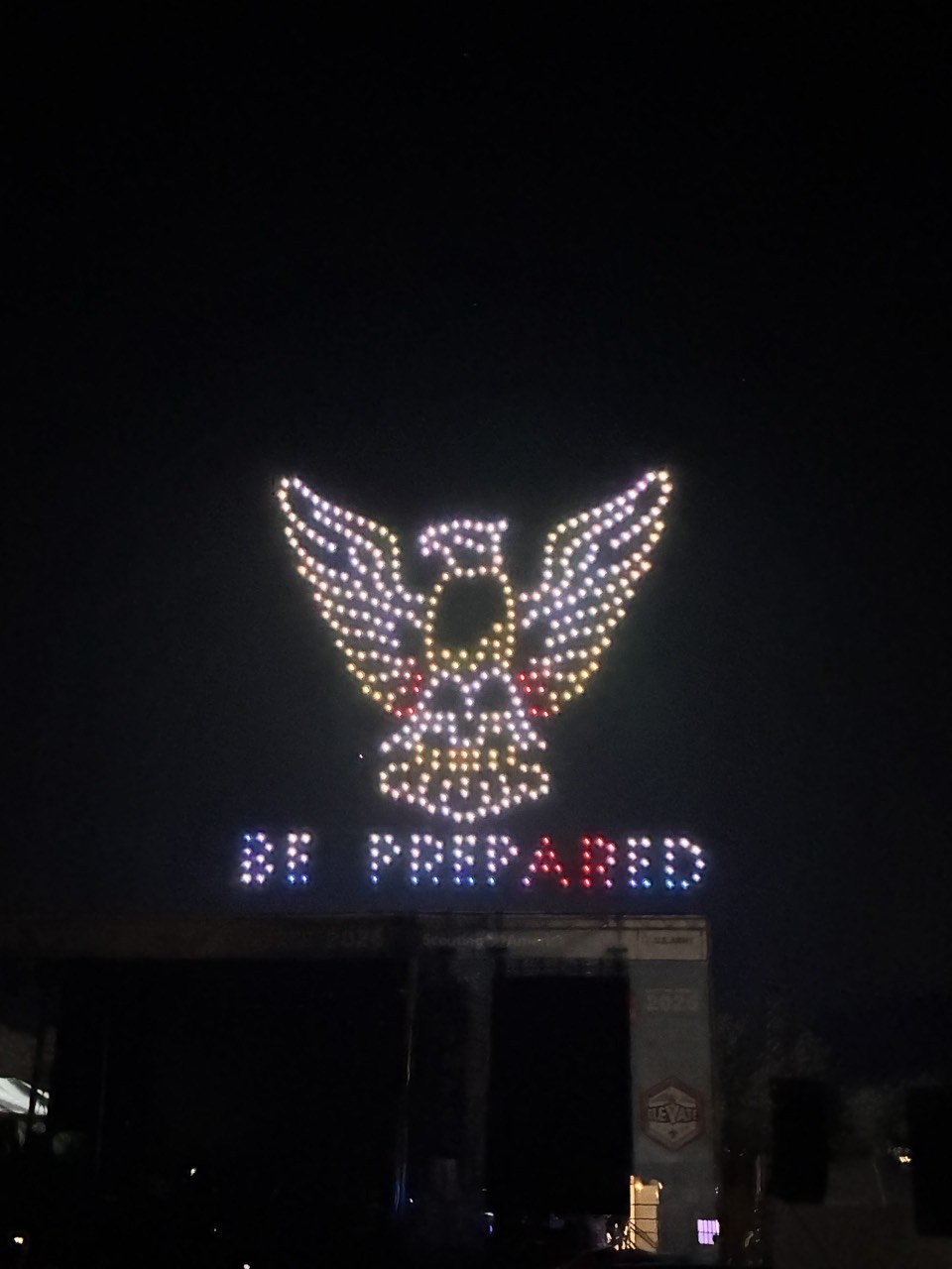 An Eagle Scout emblem formed by drones in the night sky