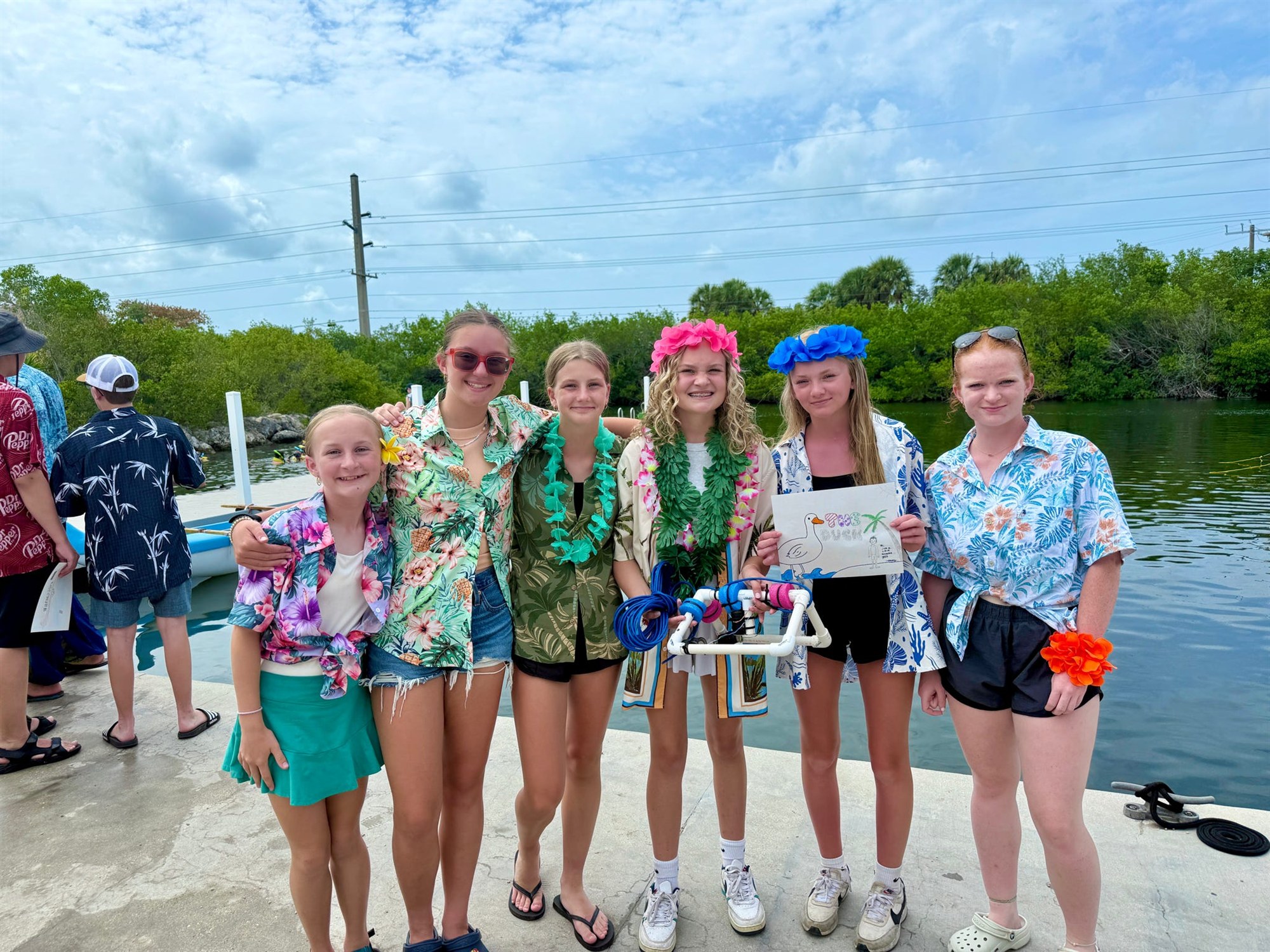 Lucy and her crew holding the underwater ROV they built